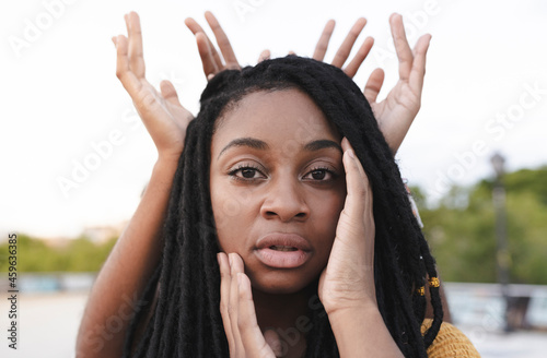 Hands of female friends making crown on woman photo