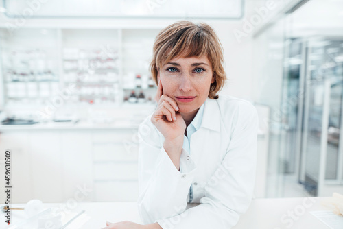 Wallpaper Mural Female pharmacist leaning on table at pharmacy Torontodigital.ca