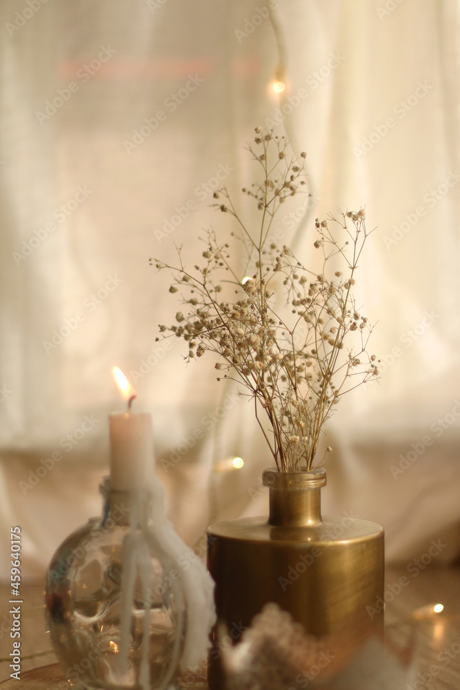 Candle holders with lit candles, vase with gypsophila flowers and bokeh lights. Hygge at home. Selective focus. Candle holders with lit candles, vase with gypsophila flowers and bokeh lights. Hygge at home. Selective focus.