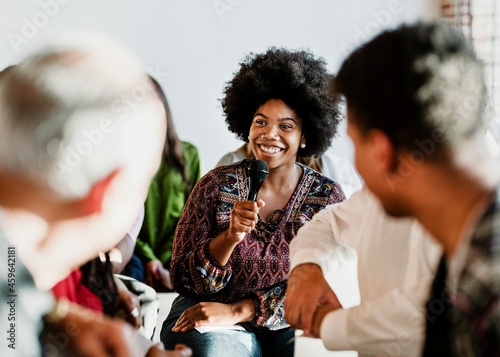 Cheerful woman speaking on a microphone in a workshop photo