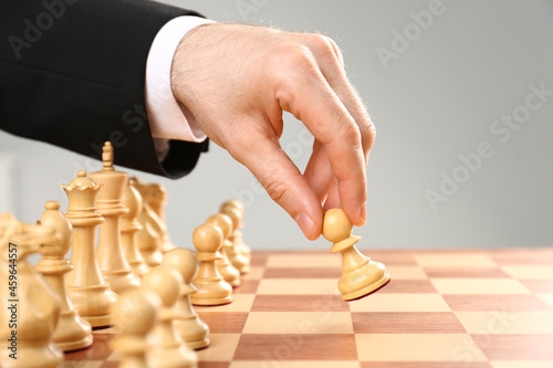 Man moving chess piece on board, closeup photo