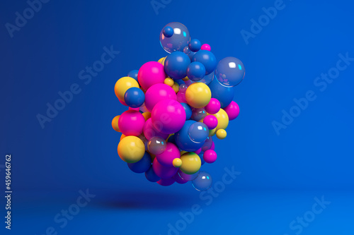 Three dimensional render of colorful spheres floating against blue background photo