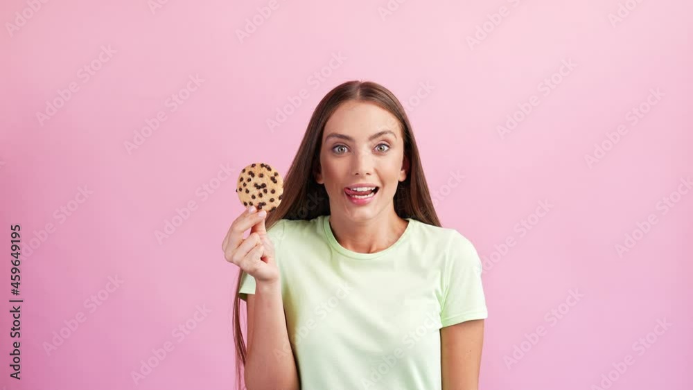 Crazy hungry funny cute lady hold tasty chocolate cookie lick tempting lips Crazy hungry funny cute lady hold tasty chocolate cookie lick tempting lips