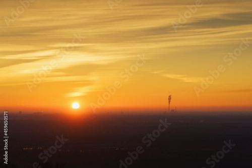 nature and industry - misty landscape from above with orange sky at sunset