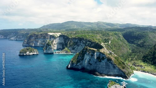 Fly around cliff and rocks over ocean along coast with amazing view on Diamond Beach, Nusa Penida, Bali, Indonesia. High quality 4k aerial footage photo