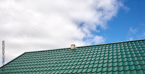 Construction of the roof of the house. Metal tiles against blue sky