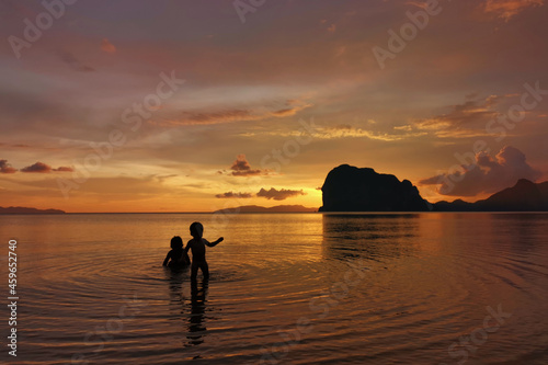 silhouette two child and sea sunset background © thekopmylife