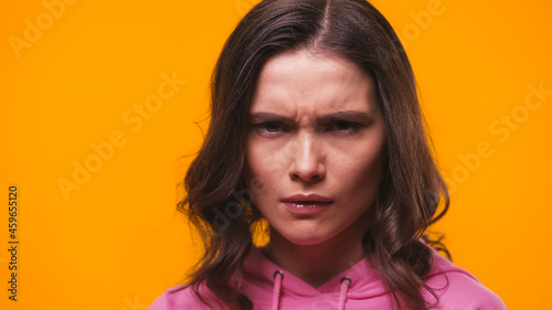 Photo grumpy woman frowning while looking at camera isolated on yellow