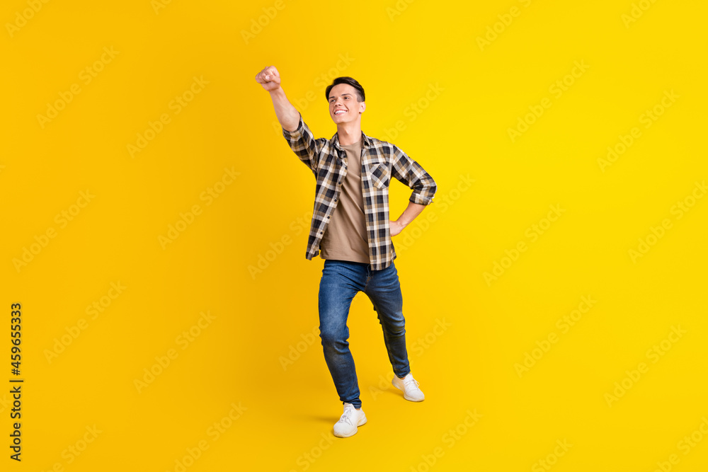 Profile photo of savior helper guy raise hand wear plaid shirt jeans footwear isolated yellow color background Profile photo of savior helper guy raise hand wear plaid shirt jeans footwear isolated yellow color background