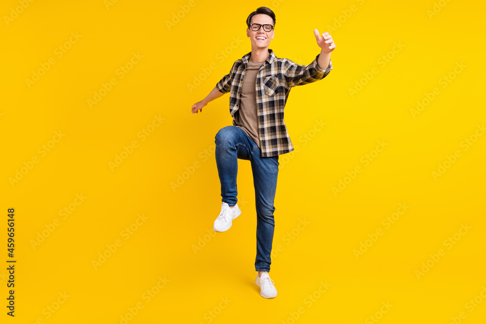 Photo of inspired dreamy guy dance enjoy party wear plaid shirt jeans shoes isolated yellow color background