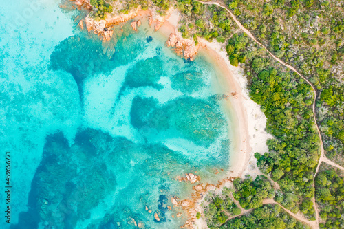 View from above, stunning aerial view of a green coastline with a white sand beach bathed by a turquoise, crystal clear water. Liscia Ruja, Costa Smeralda, Sardinia, Italy..