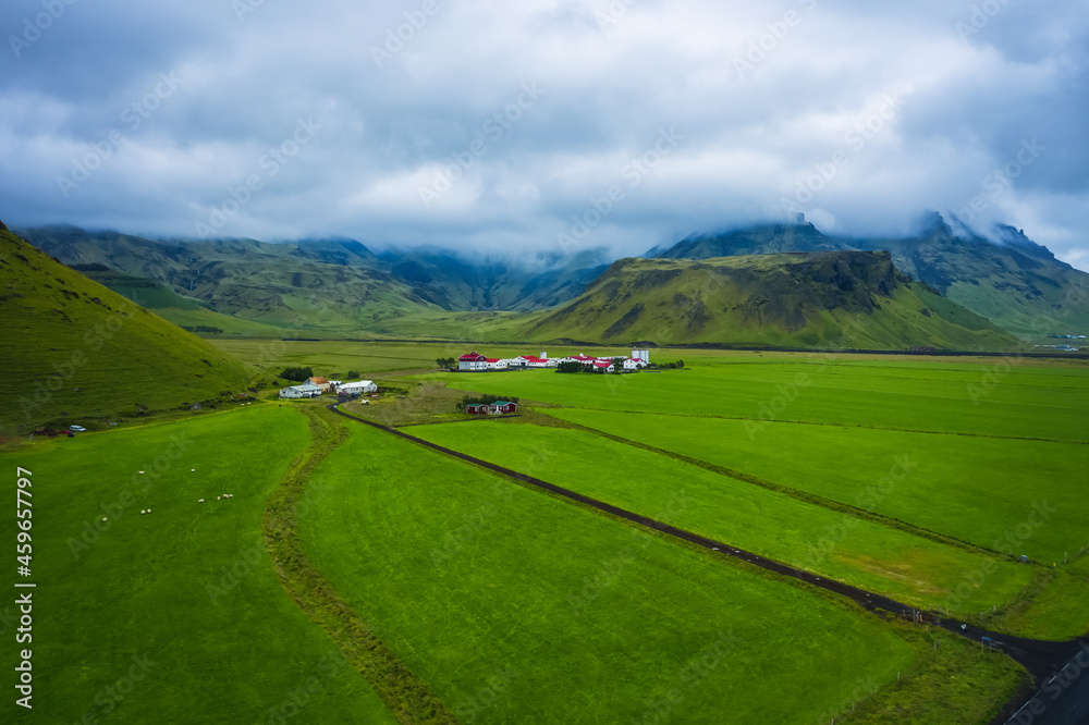 Aerial view of icelandic south coast on ring road. Landscape in Iceland at the day time. View from drone. Summer. Cloudy weather. Fresh grass on field. Travel and vacation image