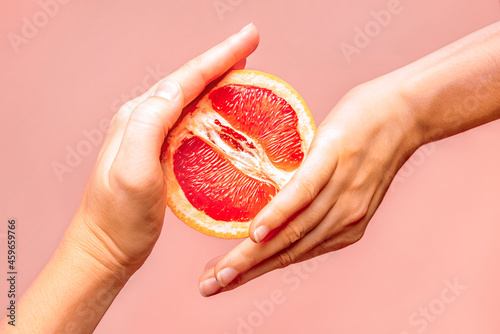 Hands holding grapefruit. Symbol of vagina. Female health, sex, menstruation concept photo