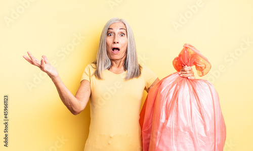 middle age pretty woman amazed, shocked and astonished with an unbelievable surprise. plastic garbaje bag photo