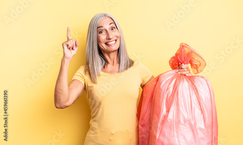 middle age pretty woman feeling like a happy and excited genius after realizing an idea. plastic garbaje bag photo