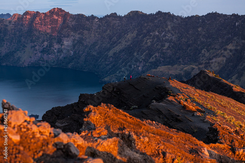 People at the edge of the volcanic crater lake Segara Anak on the summit of Rinjani, Lombok, Indonesia