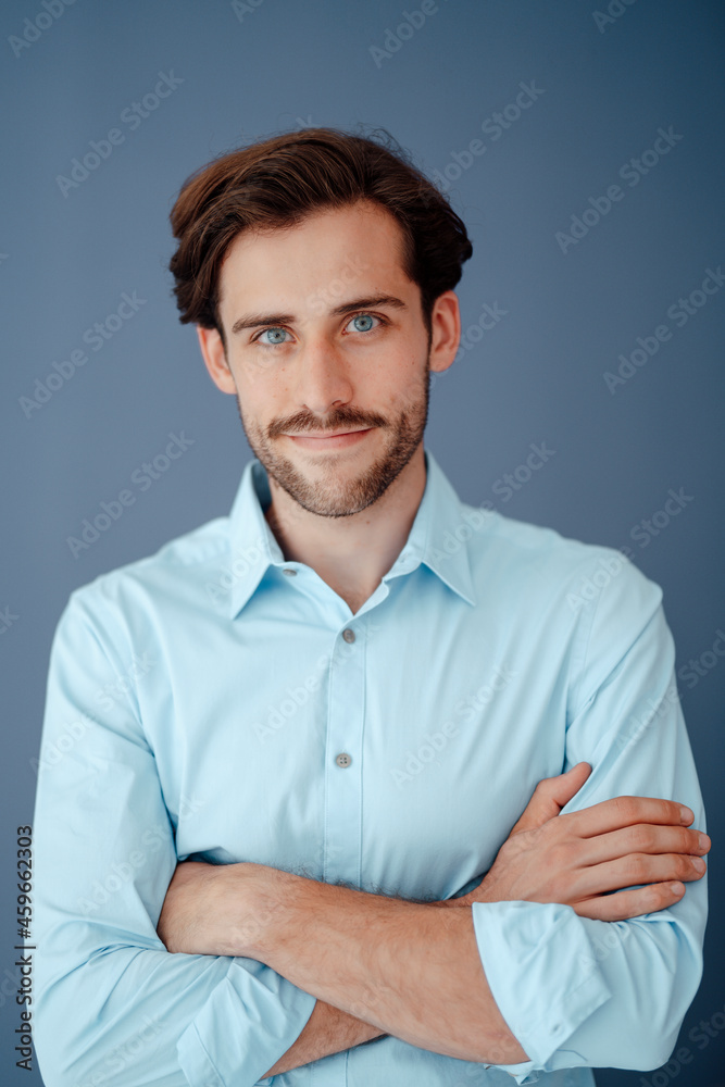 Young businessman with arms crossed against blue background Young businessman with arms crossed against blue background