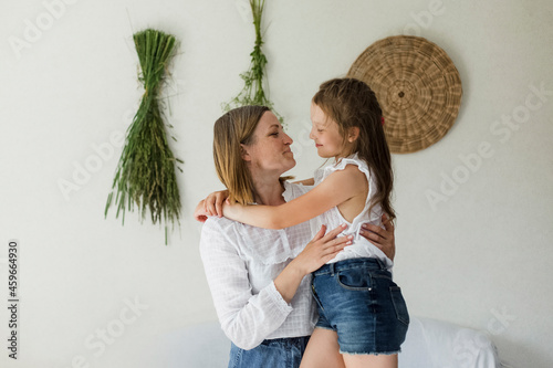 Smiling mature woman embracing daughter at home