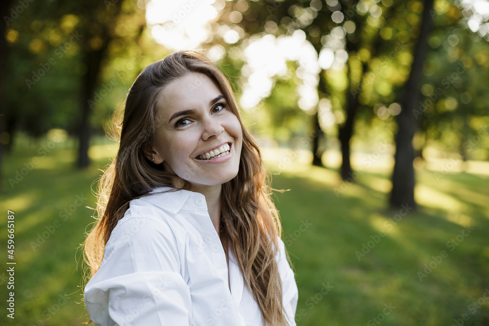 Beautiful woman with brown hair smiling at park Beautiful woman with brown hair smiling at park