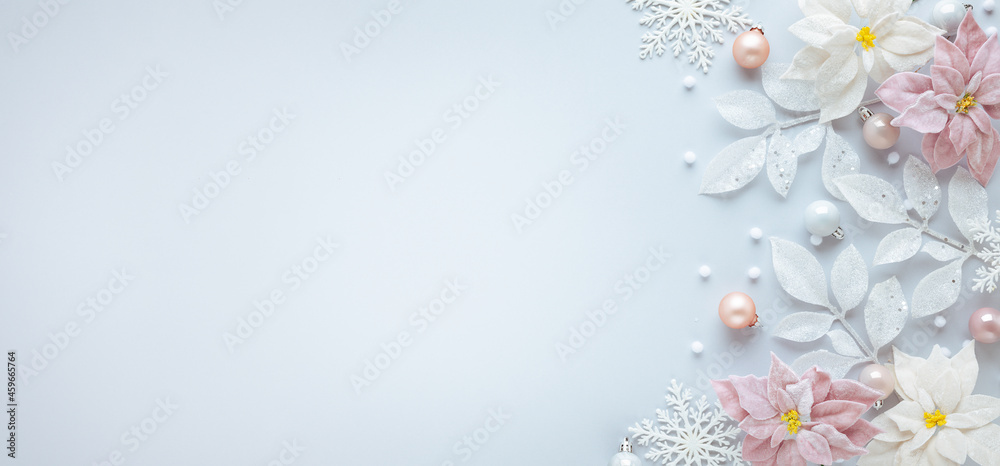 Christmas arrangement with festive baubles, poinsettia flowers and silver leaves on pastel background. Flat lay. Top view, copy space. Christmas arrangement with festive baubles, poinsettia flowers and silver leaves on pastel background. Flat lay. Top view, copy space.