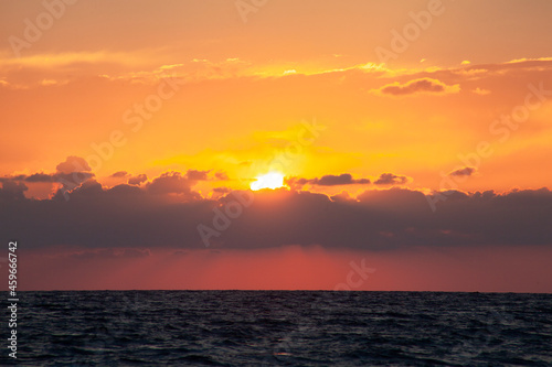 Sunset with huge sun falling on the sea at Aphrodite beach in Cyprus