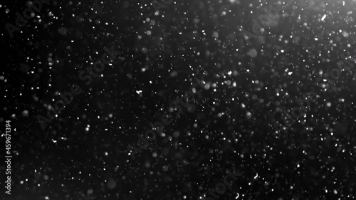 A suspension of white-silver particles in the air on a black background. Some of the particles are blurred in a beautiful bokeh. 4K background for your videos in various mixing modes.