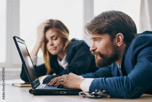 business man and woman in the office in front of a laptop career work officials
