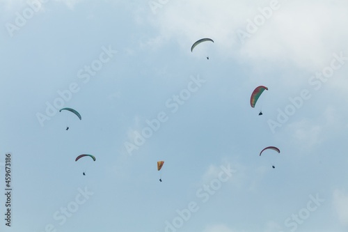 Six paragliders in multicoloured parachutes, Pokhara, Nepal