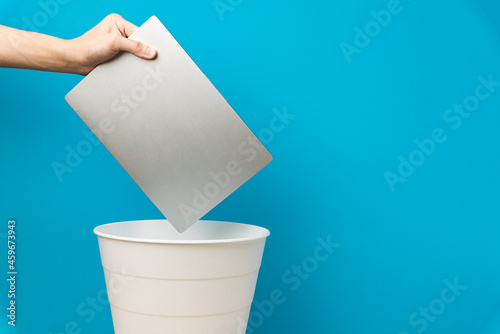 The laptop is thrown into the trash for disposal