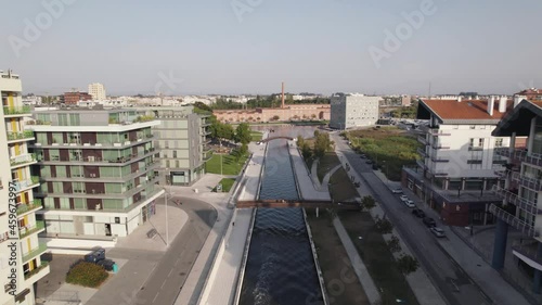 Establishing aerial dolly in shot above narrow water canal toward Aveiro Congress Center, Portugal.