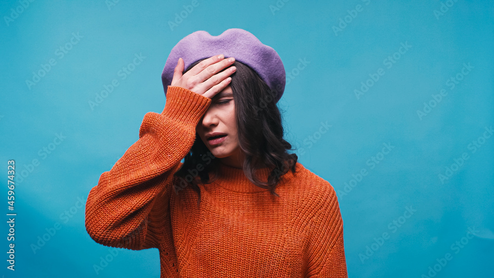 upset woman in beret showing facepalm gesture isolated on blue upset woman in beret showing facepalm gesture isolated on blue