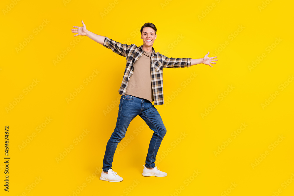 Photo of funny friendly positive guy invite embrace hug wear plaid shirt jeans shoes isolated yellow color background Photo of funny friendly positive guy invite embrace hug wear plaid shirt jeans shoes isolated yellow color background