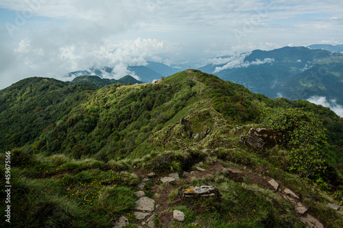 Magnificent view of the green-capped mountains with clouds. Trek to Machapuchare, Nepal