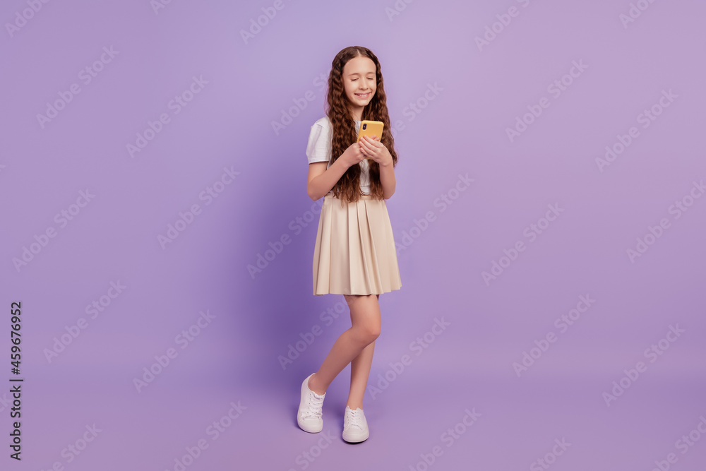 Portrait of millennial dreamy lovely girl hold cellphone browse internet on purple background