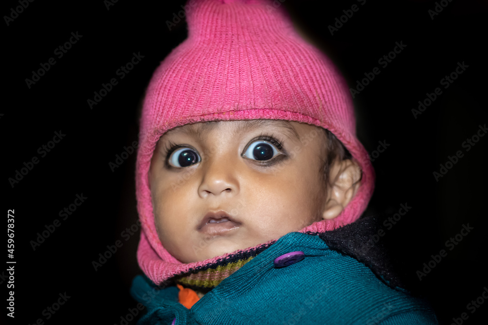 isolated toddler cute facial expression in monkey woolen cape close up shot with black background isolated toddler cute facial expression in monkey woolen cape close up shot with black background