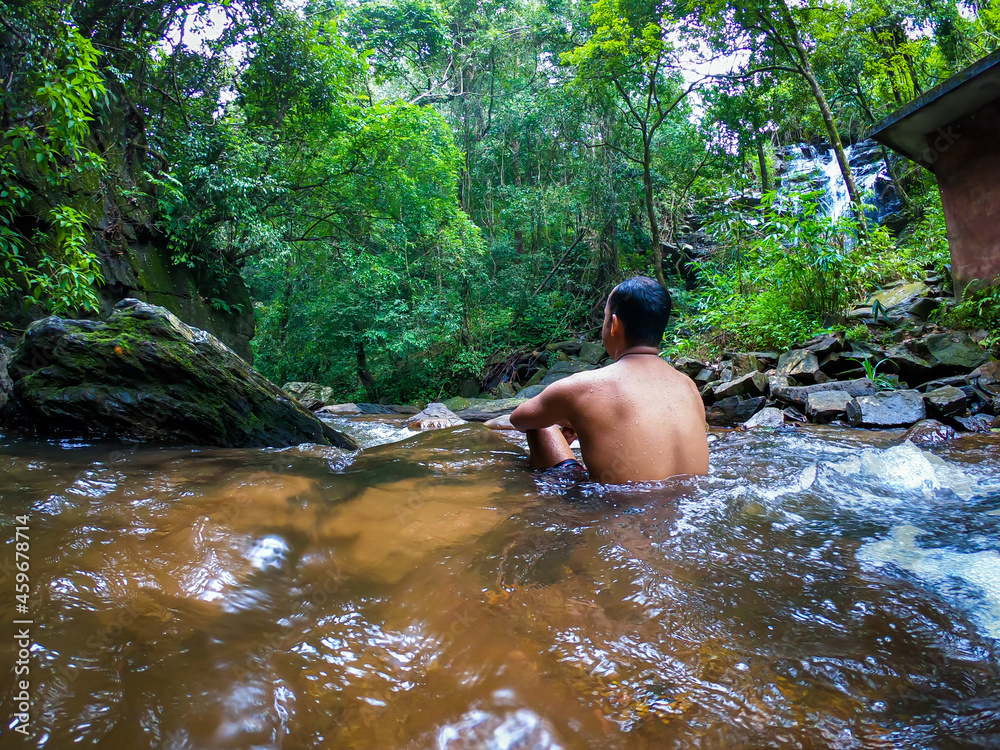 man in silence in natural waterfall at green forests from different angle man in silence in natural waterfall at green forests from different angle