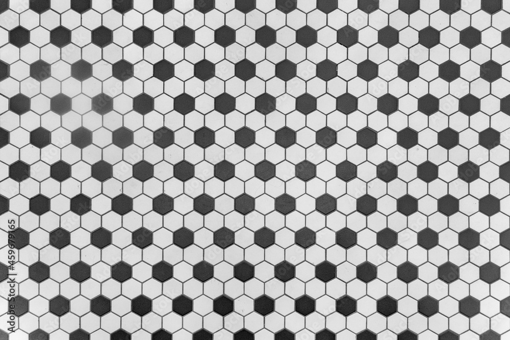 Texture of a mosaic floor made of hexagonal tiles in black