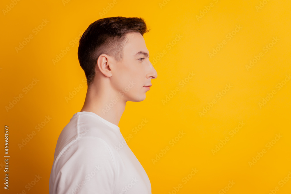 Profile portrait of nice confident guy look empty blank space on yellow background Profile portrait of nice confident guy look empty blank space on yellow background