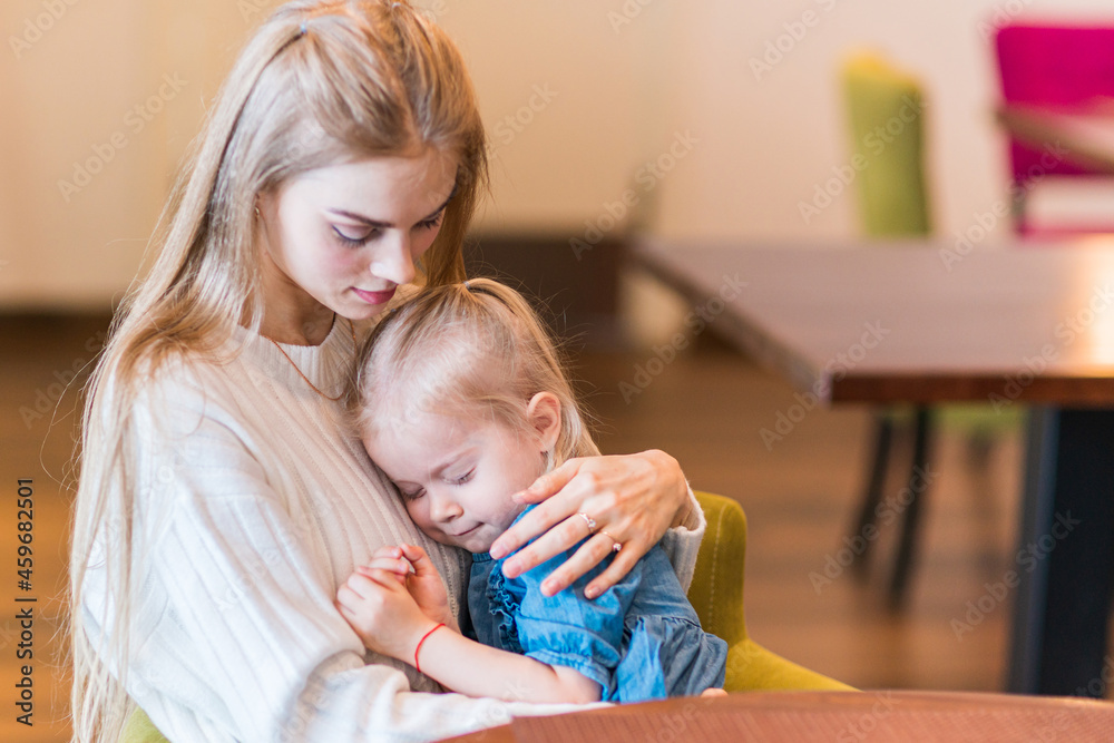 Baby sleeping beautifully in the arms of the mother.