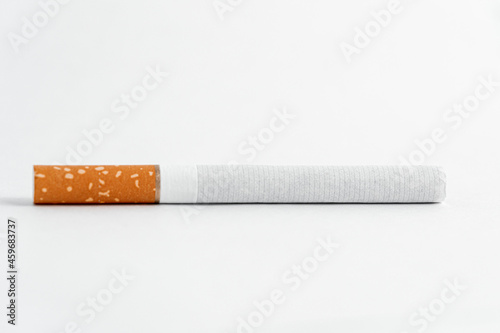 Single cigarette on white background. Copy Space. Close up.