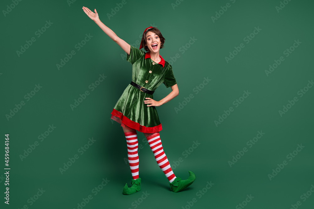 Full length body size view of attractive cheerful funny girl elf having fun celebratory isolated over green color background Full length body size view of attractive cheerful funny girl elf having fun celebratory isolated over green color background
