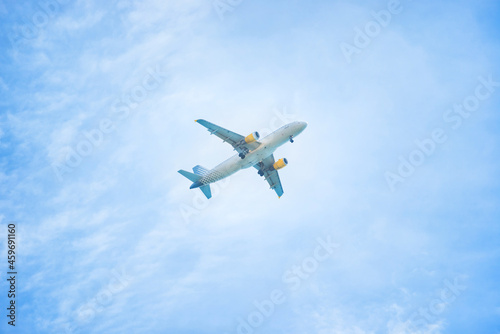 Plane flying in the blue sky with white clouds