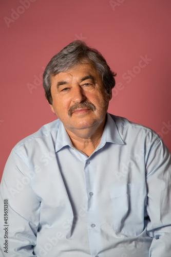 Portrait of elderly man on pink color background