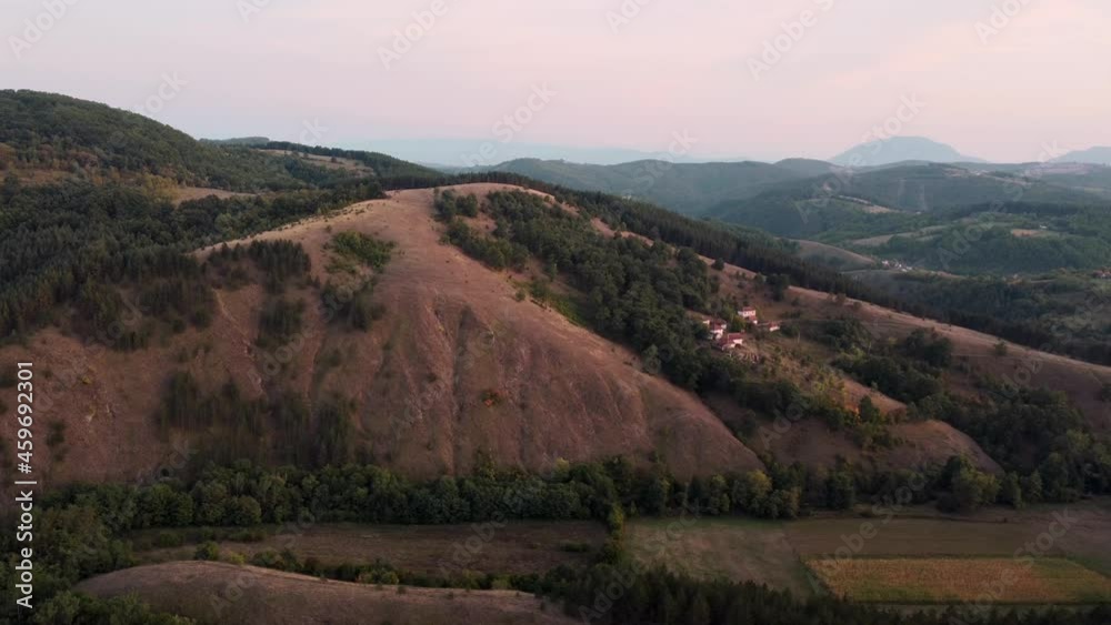 Flying over hills at sunset, pine tree forests and grassy hills at golden hour, aerial footage Flying over hills at sunset, pine tree forests and grassy hills at golden hour, aerial footage