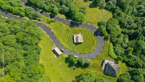 Aerial panorama of secluded huts along hairpin curve of winding mountain road photo