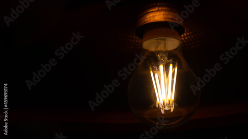 Vintage hanging light bulb on a dark background. Loft style.