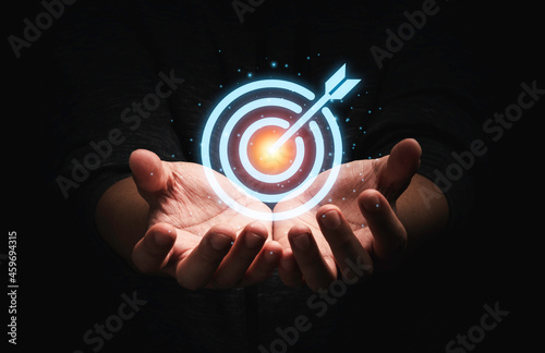 Businessman holding virtual dartboard with arrow ,setup Business Achievement objective target concept.