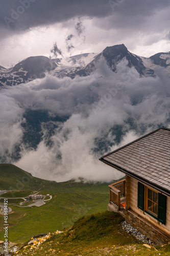 Wooden Cabin Log in High Alpine Mountains Dramatic Clouds and Storm Weather