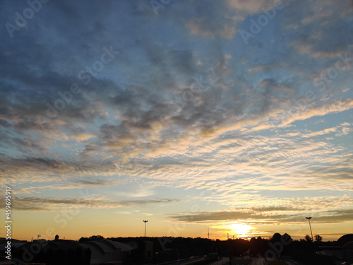Evening sky with beautiful clouds on the background of the urban landscape © neprolet