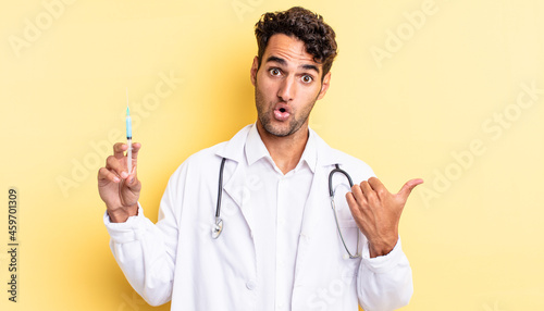 hispanic handsome man looking astonished in disbelief physician and srynge concept photo